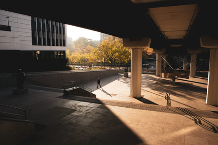 Spain, Madrid. November 19, 2023. City street flooded with sunlight, long contrasting shadows on...