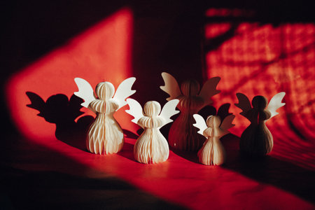 DIY paper angels. Hand made white angel on red background. New Year creative toys. Christmas greeting card. Craft decor. Faith and religion concept.の写真素材