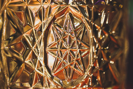 Lead diamond crystal in sunlight. Beautiful rippled glass. Glass vase illuminated with warm light. Octagram - eight-rayed star symbol macro photo.の写真素材