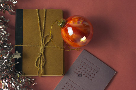 Calendar with marked date December 31, Christmas tree ball, kraft notebook. New Year 2024 gift,...
