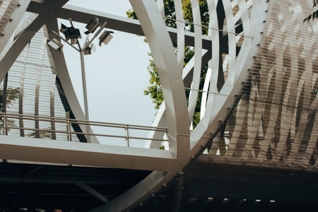 Modern overhead tunnel pedestrian metal air bridge exterior in city park, garden. Urban infrastructure landscape. Footbridge corridor. Steel structureの写真素材