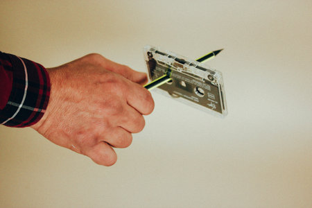 Madrid, Spain. January 2, 2024 Man is rewinding with a pen an old vintage cassette for tape recorder...