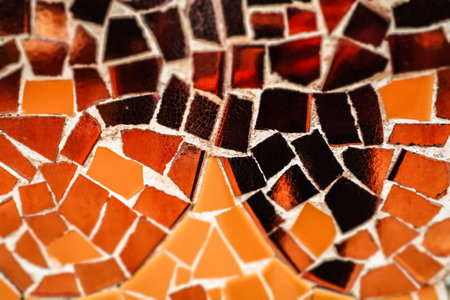 Multicolored orange, yellow ceramic mosaic details. Colorful artwork abstract background. Architecture decoration. Mosaics wall surface macro photo.の写真素材