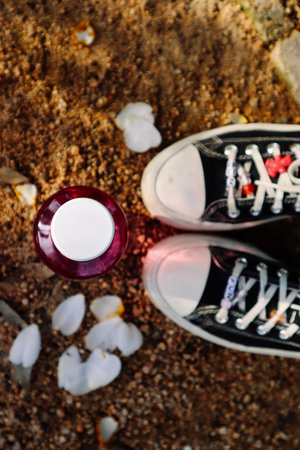 Madrid, Spain. January 7, 2024 Black white pale sneakers Converse on womens feet, plastic water...