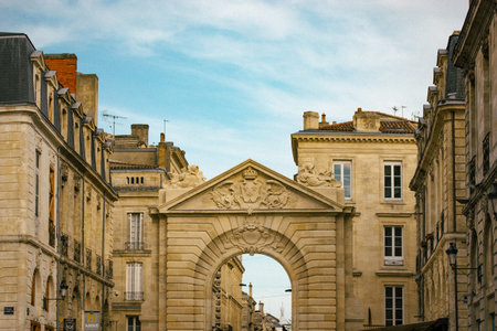 Bordeaux, France. May 2, 2023 Burgundy Gate triumphal arch in daytime. Medieval architecture on old city street. Travel postcard. Typical houses roofsのeditorial素材