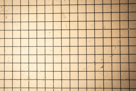 A sheet of paper with a checkered print. School notebook with blank pages top view. Brow yellow...