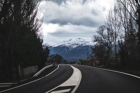 Empty misty road through winter forest. Scenic picturesque route. Sense of journey, exploration. Dark landscape in winter. Scary route in nowhere.の写真素材