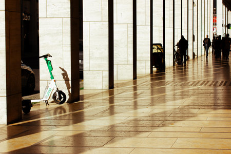 Berlin, Germany. October 3, 2023 Corridor, passage with columns in perspective. City dwellers, urban people lifestyle. Morning light on a sidewalk.のeditorial素材