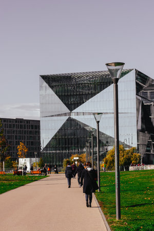 Berlin, Germany. 2 October 2023 Modern architecture with mirror building facade and a pathway to a business center. People walking o a city street.のeditorial素材