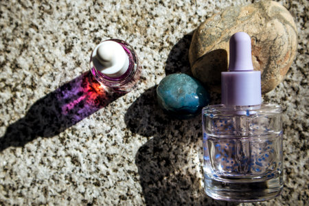Cuticle oil, facial skin essence, serum in a dropper bottle. Natural decorative cosmetics on stone background flatly. Aesthetics and beauty concept.の写真素材