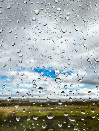 Extremely close up macro drops of water on a wet glass on natural green background. Raindrops...