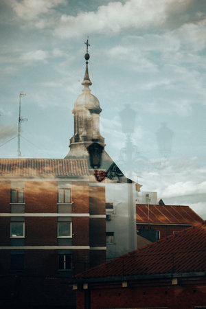 Artistic cinematic style photography with urban old European architecture. Blue evening town and roofs of houses, trees, street lamp. Overlay effect.の写真素材