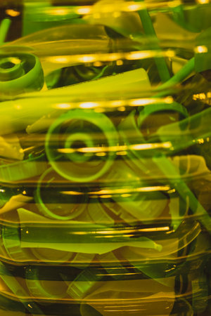 Recycling green plastic bottle caps to be reused for manufacturing. New life to the old trash things concept. Plastic shredder Process of repurposing.の写真素材
