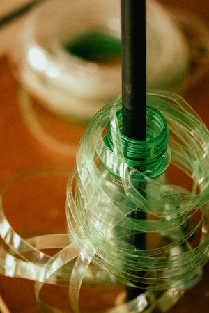 Recycling green plastic bottle to be reused for manufacturing. New life given to the old trash things concept. Plastic shredder Process of repurposingの写真素材