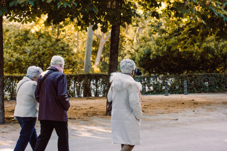 Madrid, Spain. 1 May 2024 Senior women with Gray Hair walking in autumnal city park, garden. Retired Adult female friendship. Old people on a walk.のeditorial素材