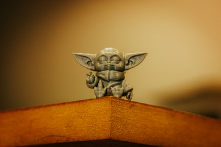 Madrid, Spain 7 May 2024 Din Grogu, Star wars toy hero made of recycling plastic isolated on yellow background. Happy baby Yoda from Disney series.のeditorial素材