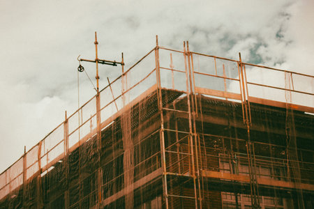 Construction residential buildings corner. Housing industry. Construction building with protective net. Unfinished multistory houses. Real estate.の写真素材