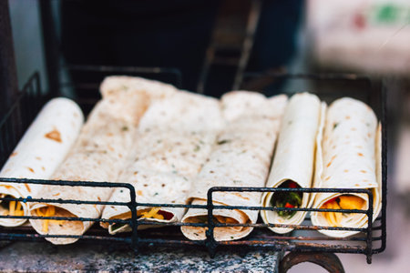 Flatbreads rolled and filled with cheese and vegetables. BBQ cooking process outdoors. Vegetarian...