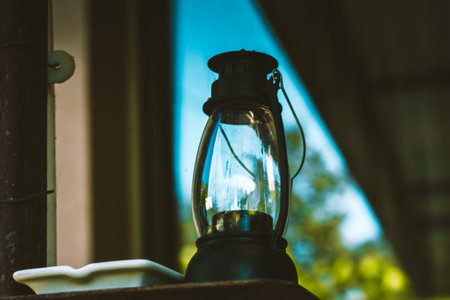 Black metal glass kerosene portable vintage retro lamp for outdoor lighting in home garden. Decor for a backyard on natural green natural background.の写真素材