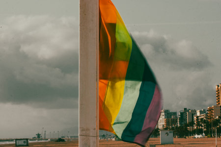 Colorful rainbow LGBT flag waving in a wind against sky in sunny day. Gay parade, Pride month 2025...
