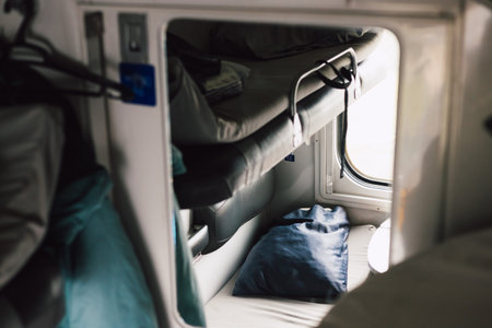 Inside a train cabin - a bed, pillow ready for a comfortable train trip. A cozy lower berth, ready...