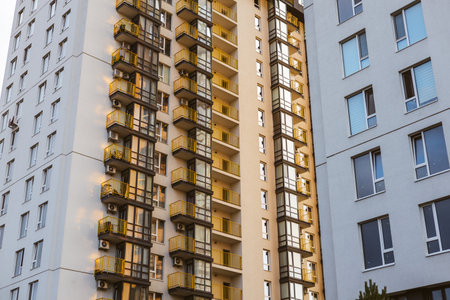 Modern architecture features a high-rise apartment building with a lot of windows and balconies. Modern residential buildings with balconies and windows, a beautiful architectural structure.の写真素材