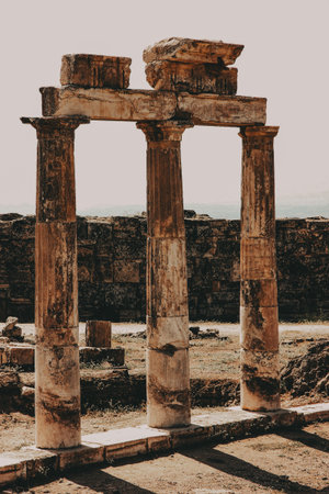 Ancient pillars in a historical site The image features three aged pillars, remnants of an ancient structure set against a rustic backdrop, hinting at a rich history.の写真素材