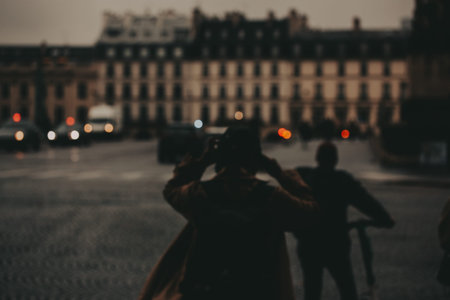 Blurred cityscape with people in silhouette. A blurry shot of a city street with people in silhouette, with buildings and lights in the background, creating a moody atmosphere. Moody urban scene.の写真素材