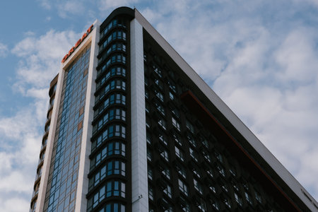 KYIV, Ukraine 4 October 2025 Modern high-rise building with glass windows against a cloudy sky. The architectural design of this building, modern urban development. Residential complex Great.のeditorial素材