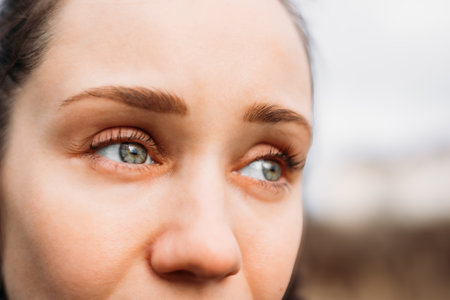 close-up of a woman's eyes with green-blue irises, looking off to the side. This close-up highlights shot the captivating gaze of a woman with striking green eyes, creating a sense of intrigueの写真素材