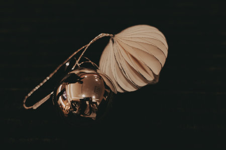 Elegant Christmas ornaments with - a silver glass ball with a reflective surface and paper decoration. The image showcases a pair of festive ornaments, perfect for holiday-themed projects and designs.の写真素材