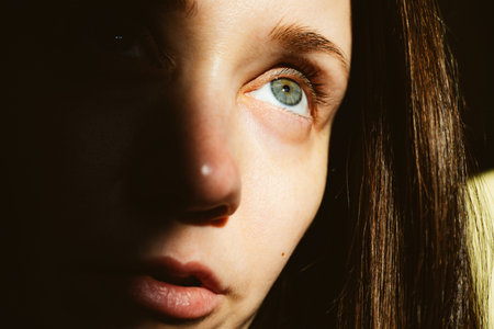 Cinematic close-up portrait of a young white woman with blue eyes. Dramatic sunlight and hard...