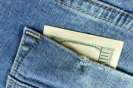 Hundred dollar bill in jeans pocket. Close up