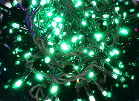 Rolled up Christmas garland with green glowing bulbsの写真素材