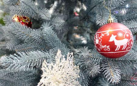 Red christmas ball with ornament on a festive treeの写真素材