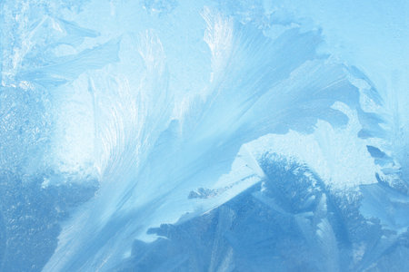 Frosty natural pattern on winter window glass. Abstract background.
