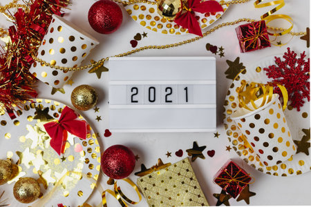 Happy new year 2021 table light box with party cup,party blower,tinsel,confetti.Fun Celebration holiday party time table flat lay invitation or greeting card. New year eve concept on whiteの写真素材