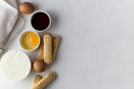 Ingredients for tiramisu, preparing tiramisu. Eggs, ladies finger cookies, mascarpone, coffee, whisk for beating eggs on a white background.の写真素材