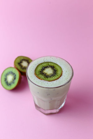 Kiwi milkshake garnished with a kiwi wedge and kiwi halves in a cocktail glassの写真素材