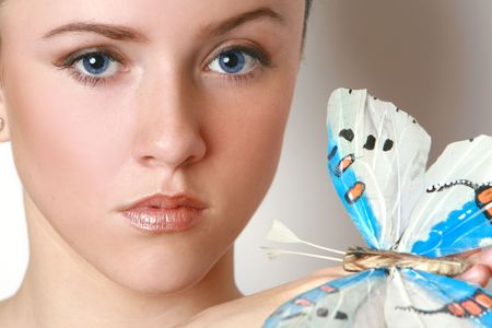 Blue-eyed brunette with a butterflyの写真素材