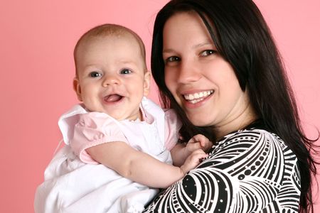 Happy mom and daughter on pink backgroundの写真素材