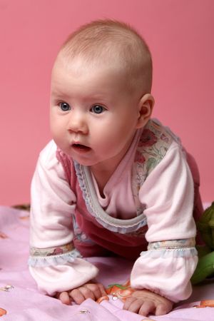 Portrait of young little baby girl on pink backgroundの写真素材