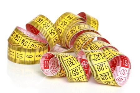 Yellow measuring tape with reflection on a white backgroundの写真素材