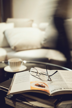 Living room sofa with coffee table book eyeglassesの写真素材