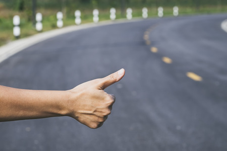 Hitchhiker sign thumb up on Highway road Outdoorの写真素材