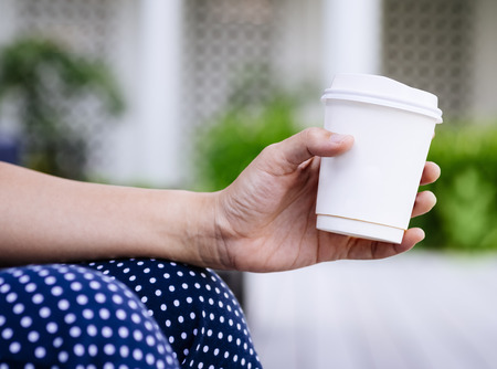 Woman Hand holding Paper Cup coffee Outdoorの写真素材