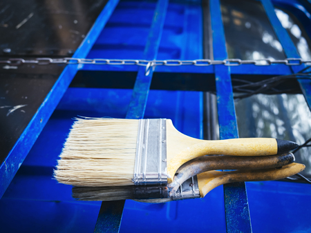 Paint brush on blue metal wall backgroundの写真素材