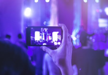 Hand holding Cell phone Camera photo shot on Concert event Crowd peopleの写真素材