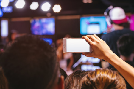 Hand holding Cell phone Blank screen Photo shot Blur Concert event Backgroundの写真素材