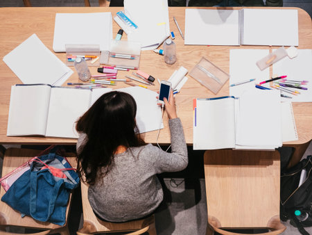 Student Top view holding phone with Book documents on table Libraryの写真素材